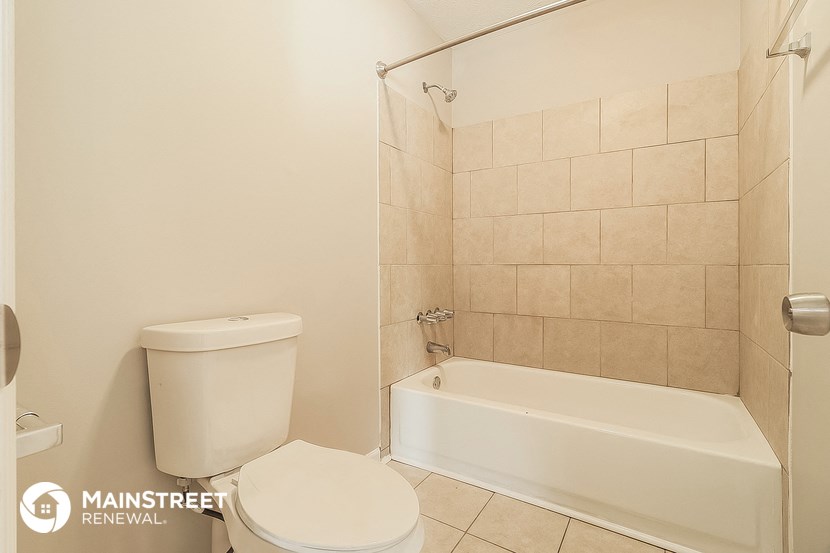 a bathroom with a toilet and a bath tub and a shower