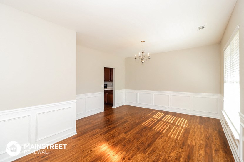an empty living room with wood floors and white walls