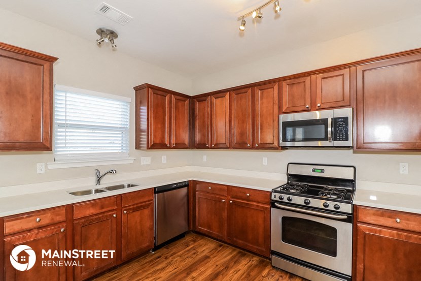 a kitchen with wooden cabinets and stainless steel appliances