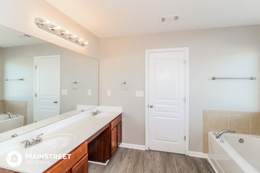 a bathroom with a large tub and a sink and a mirror