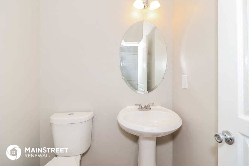a white bathroom with a sink and toilet and a mirror