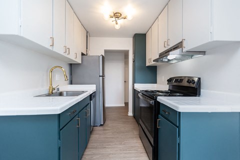 A kitchen with white cabinets and a black stove top oven.