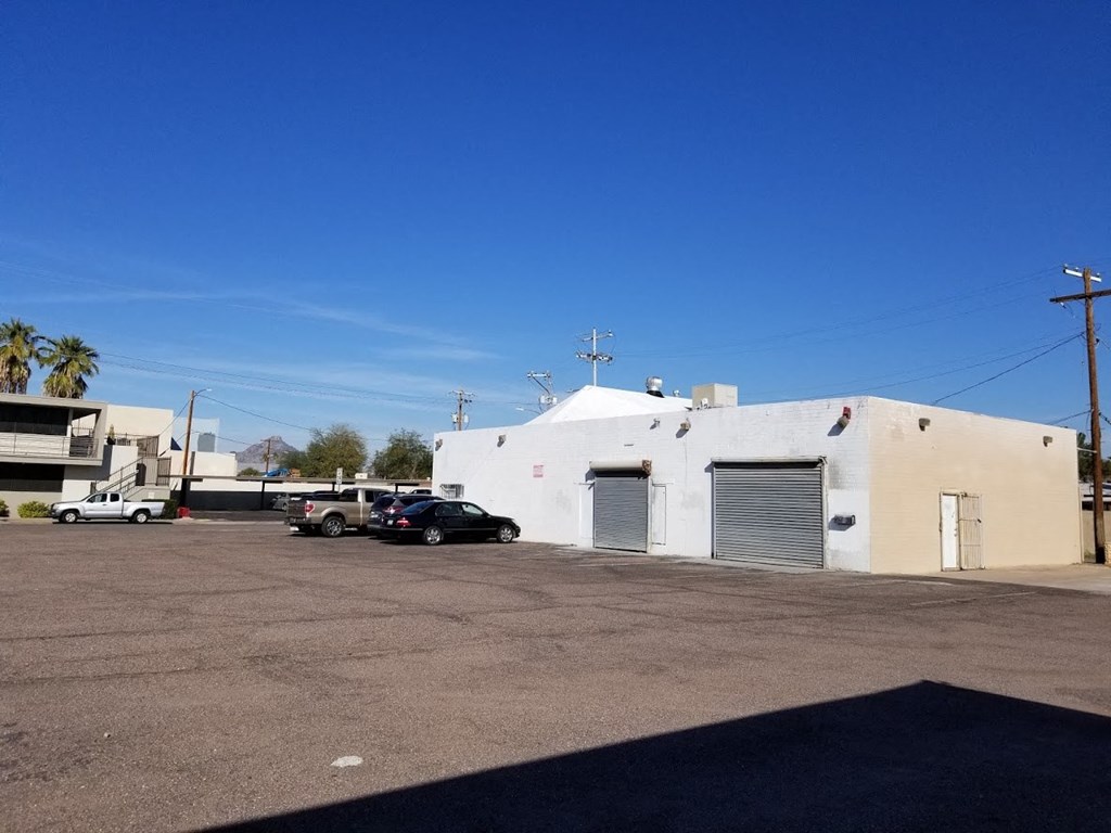 a white building with two garage doors and a parking lot