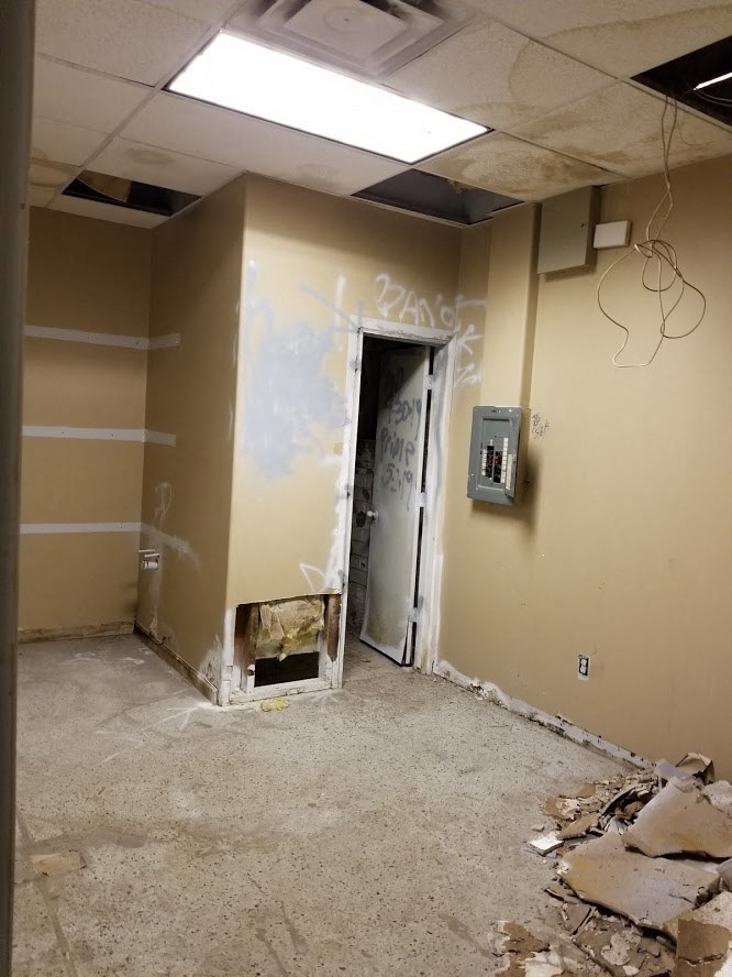 a room with a hole in the wall and a doorway