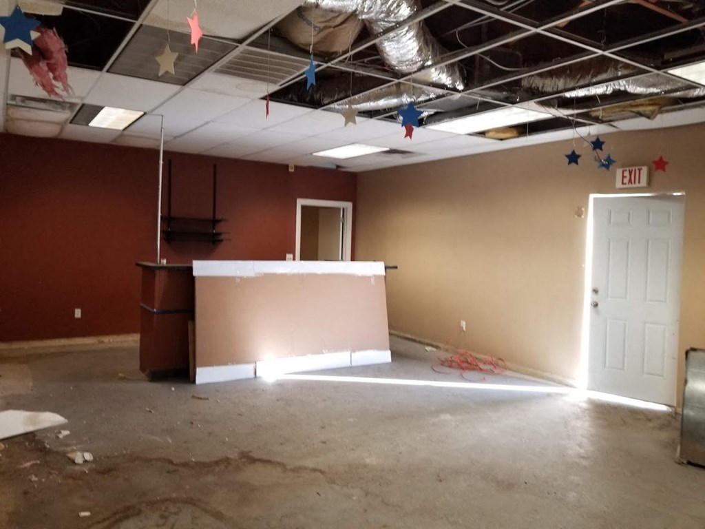 a large room with a bar in it and a white door