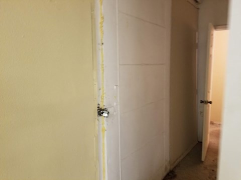 the door to the bathroom is taped off with yellow tape