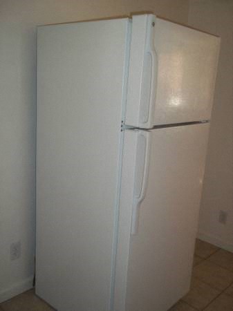 a white refrigerator in the corner of a room