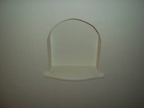 a white wall with a white shelf on it