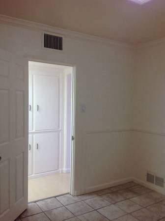 an empty room with a door and a tile floor