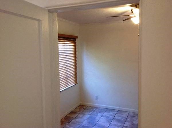 an empty room with a window and a tile floor