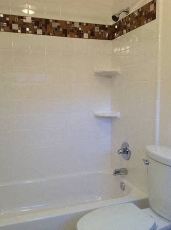 a bathroom with a white toilet and a bath tub