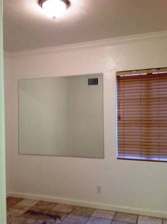 a living room with a large mirror and a window