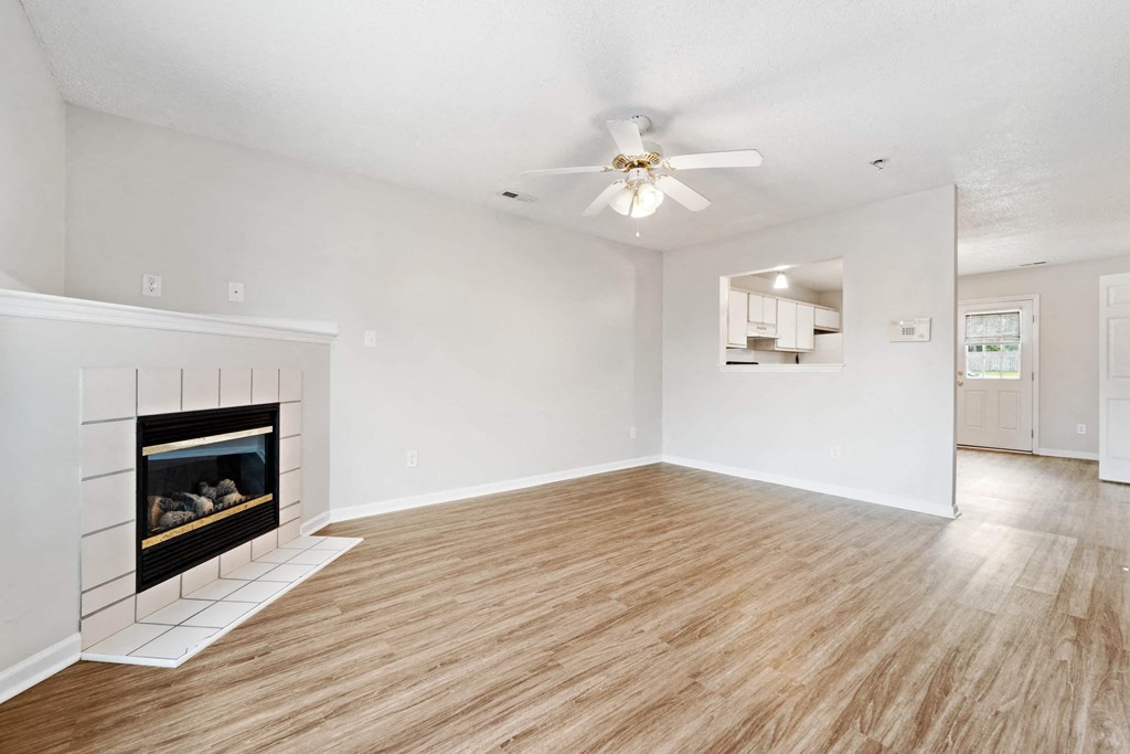 a living room with a fireplace and a ceiling fan