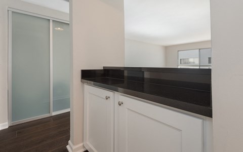 a kitchen with white cabinets and a black counter top