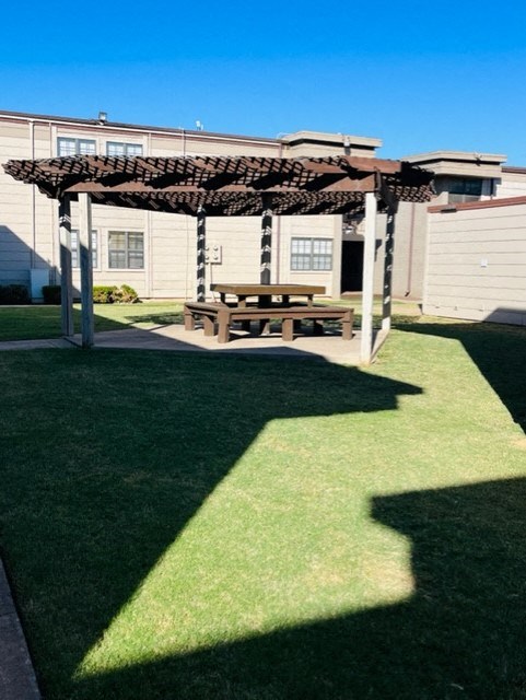 a backyard with a picnic table and a pergola