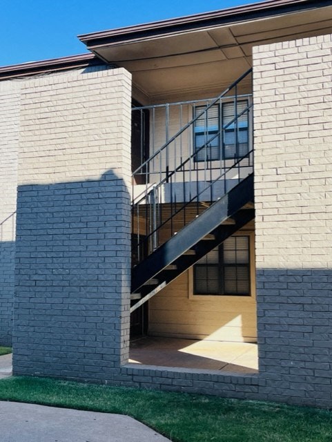 a white brick building with a metal staircase