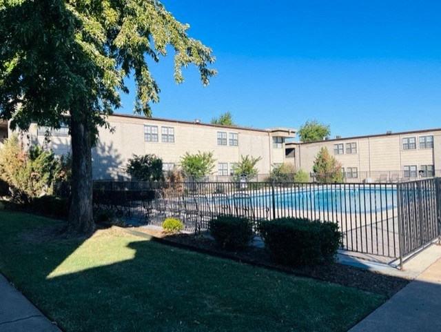 an apartment building with a swimming pool in front of it