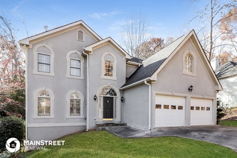 the front of a white house with a white garage door