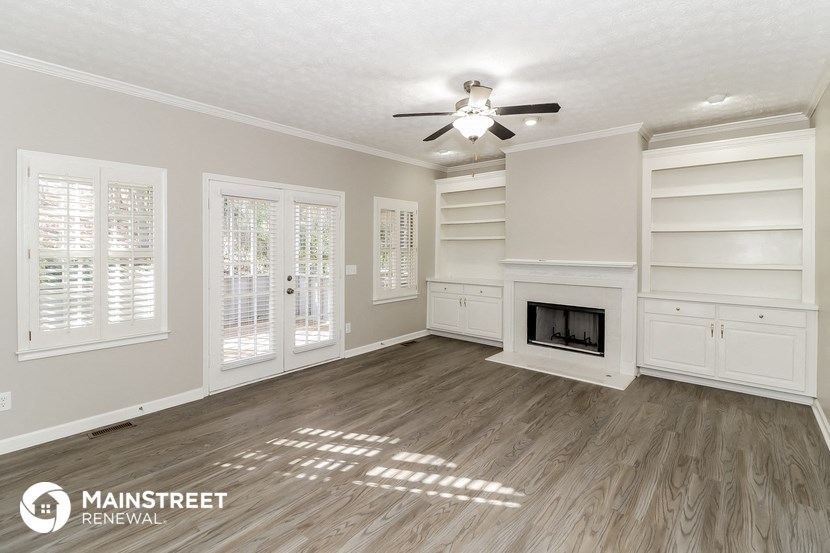 a living room with a ceiling fan and a fireplace
