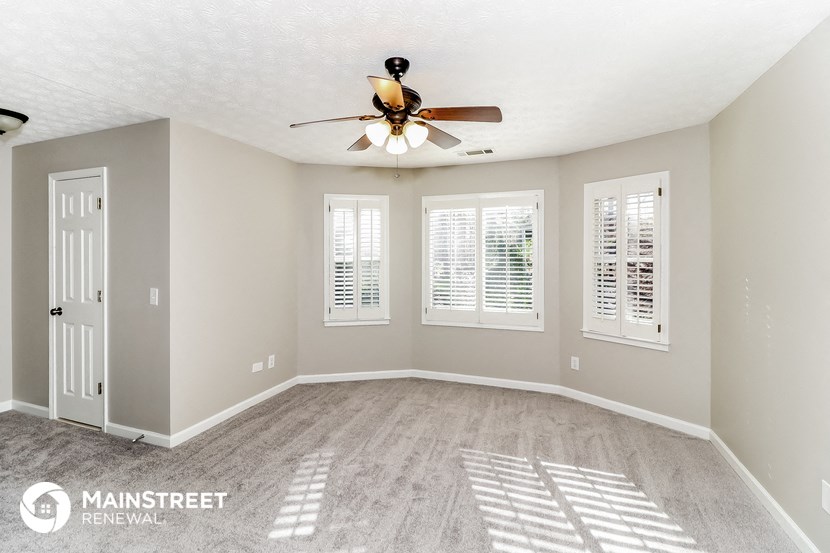 the master bedroom is spacious and clean with a ceiling fan