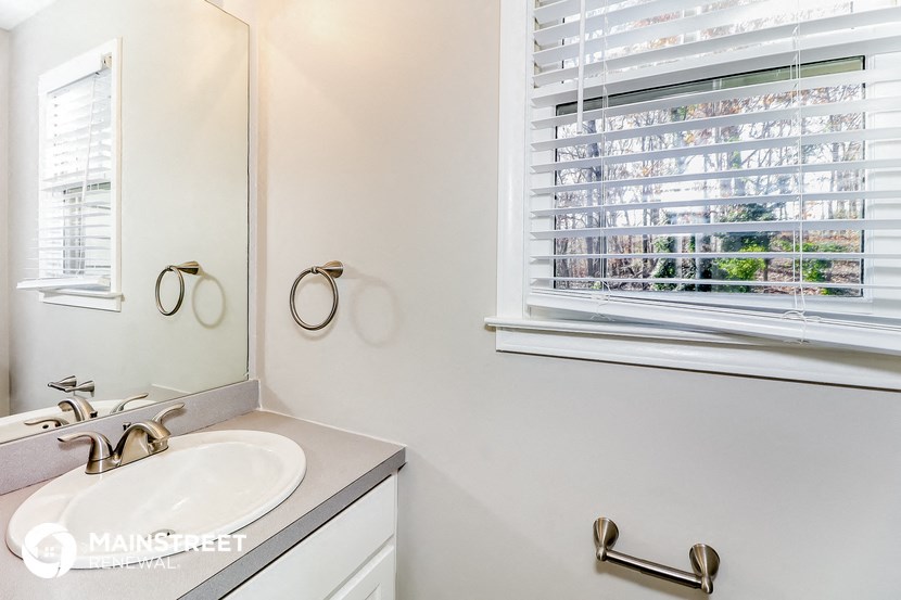 a bathroom with a sink and a mirror and a window