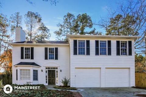 a white house with black shutters and a driveway