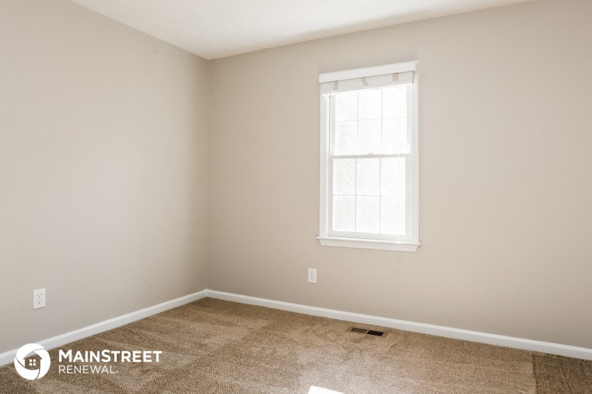 a small room with a window and a carpeted floor