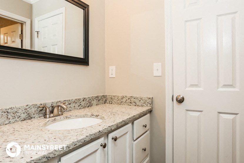 a bathroom with a sink and mirror and a white door