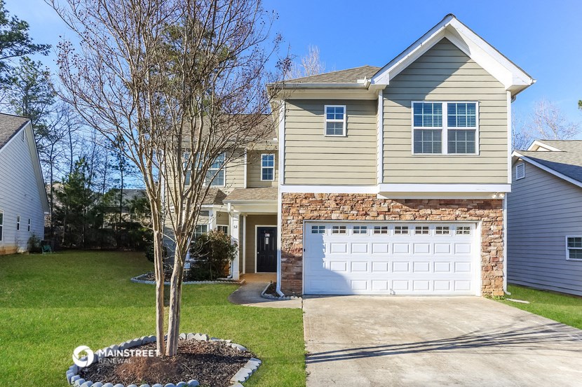 a house with a white garage door in front of a lawn