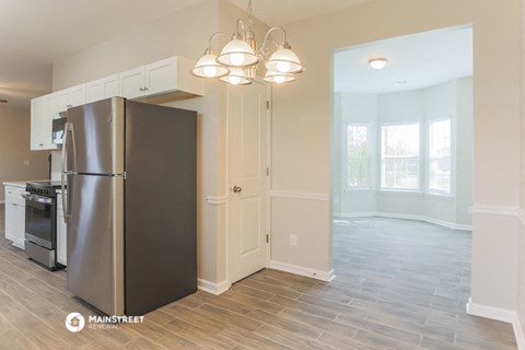 a kitchen with a stainless steel refrigerator and white cabinets