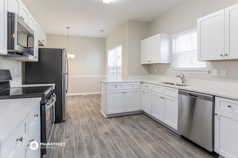 an empty kitchen with white cabinets and stainless steel appliances