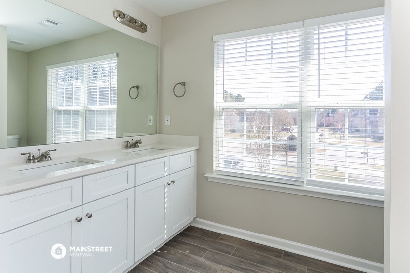 a bathroom with two sinks and a large window