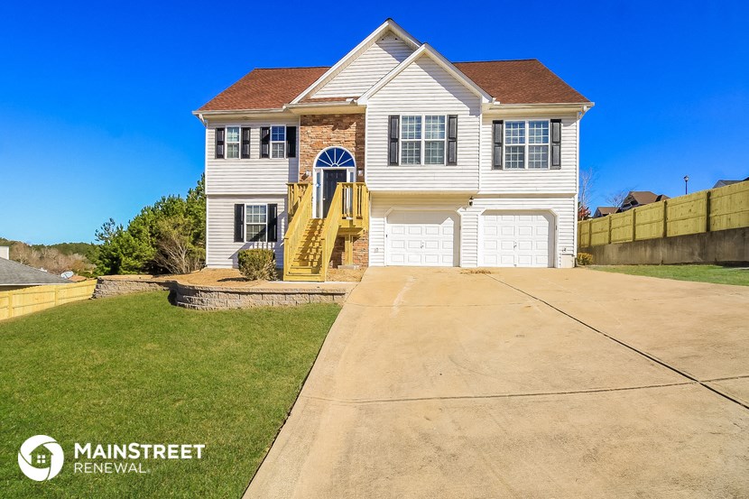 a white house with a driveway and a garage door