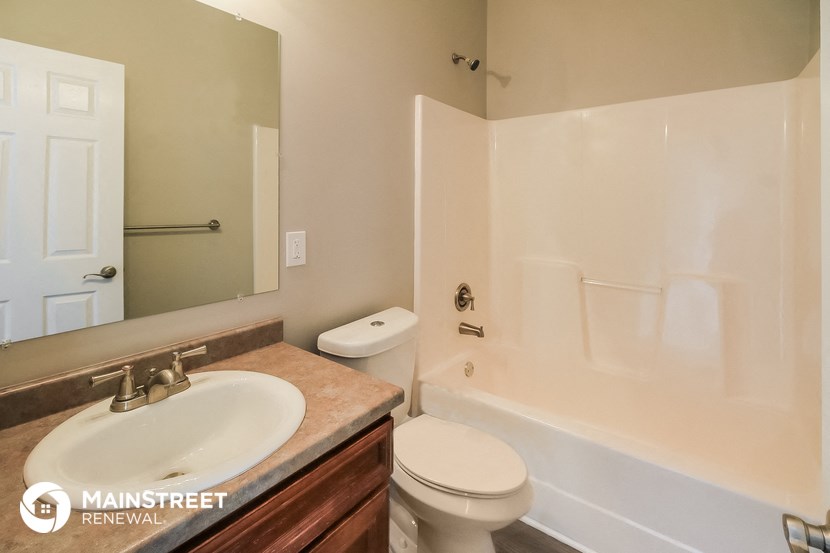 a bathroom with a sink toilet and tub and a mirror