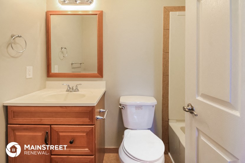 a bathroom with a toilet sink and mirror and a shower