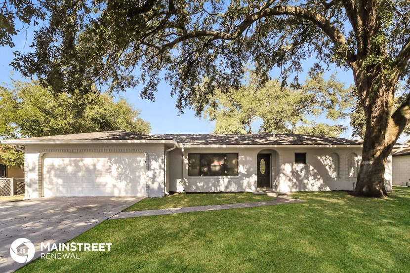 a white house with a yard and a tree