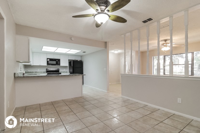 an open kitchen and living room with a ceiling fan