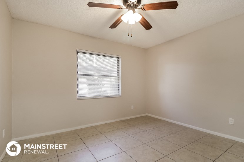 the living room of an empty home with a ceiling fan