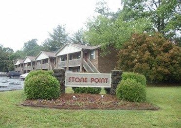 A sign that says Stone Point in front of some houses.