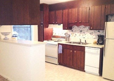 A kitchen with wooden cabinets and a white fridge.