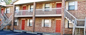 A red brick building with white railings and doors.