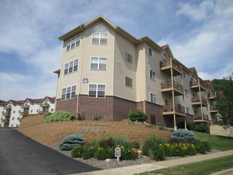 an apartment building on a hill with a garden in front of it
