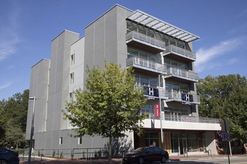 A modern building with a glass balcony on the second floor.