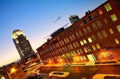 a city street at night with tall buildings