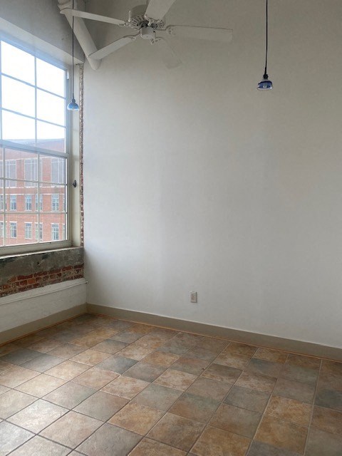 an empty room with a large window and a tiled floor