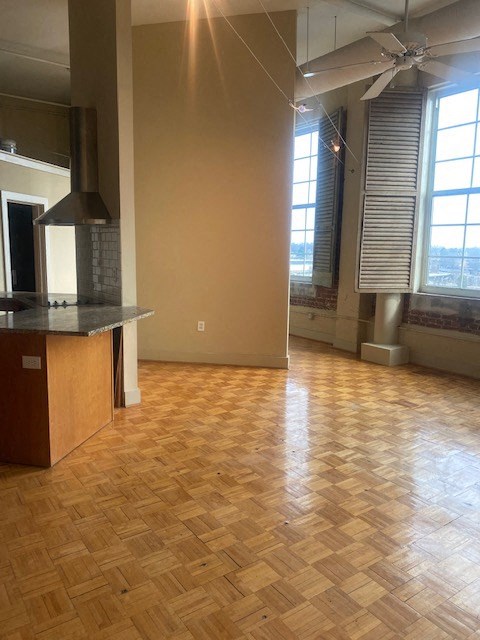an empty room with a kitchen and a wood floor