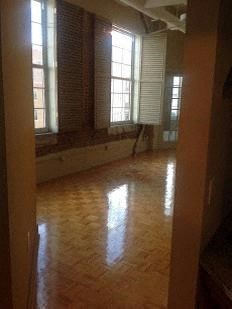an empty room with windows and a wooden floor
