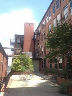a courtyard between two tall buildings with trees