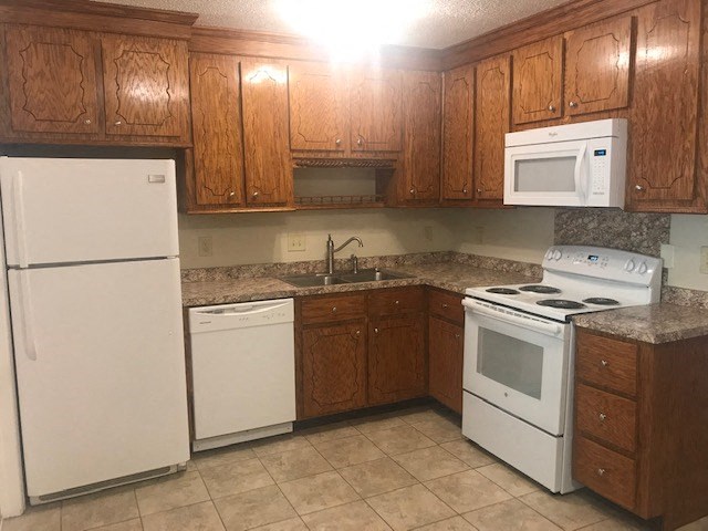 a kitchen with white appliances and wooden cabinets