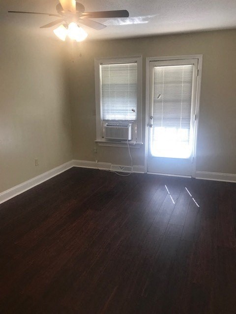 an empty room with a window and a ceiling fan